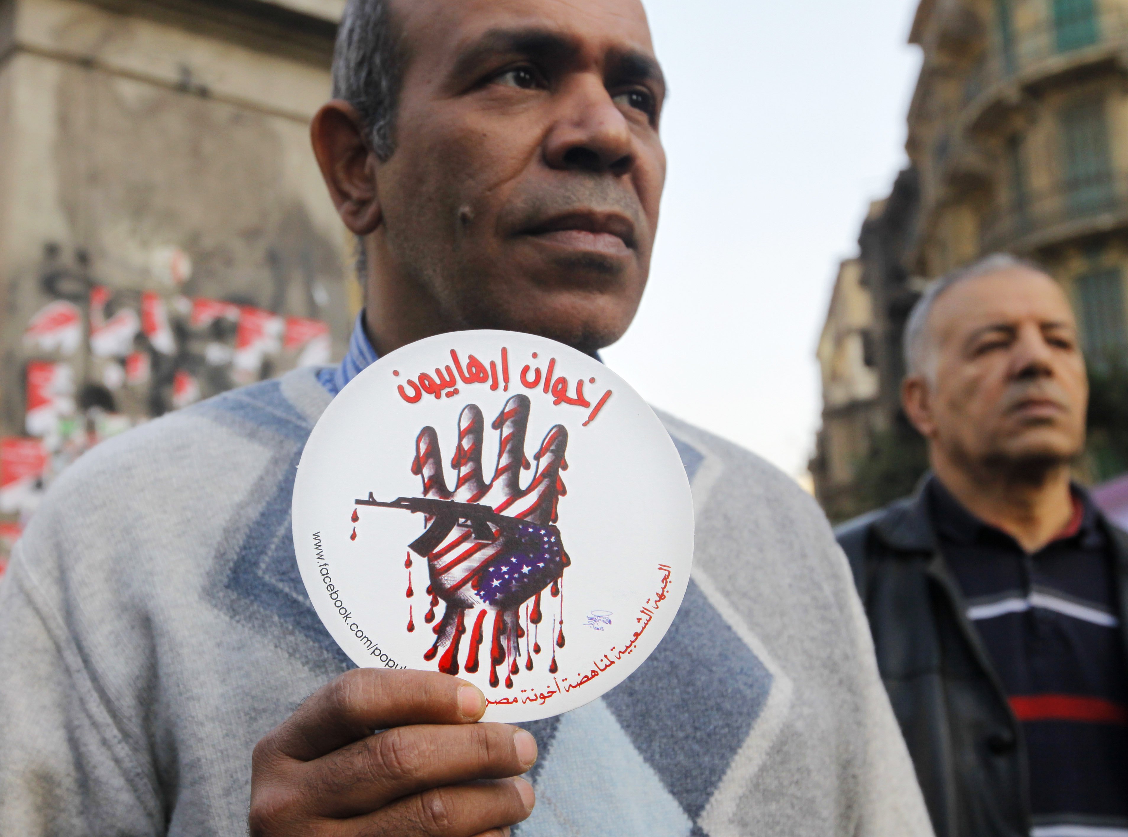 An Egyptian activist holds an anti-terrorism image with Arabic text that reads, "terrorists brotherhood". Photo: AP