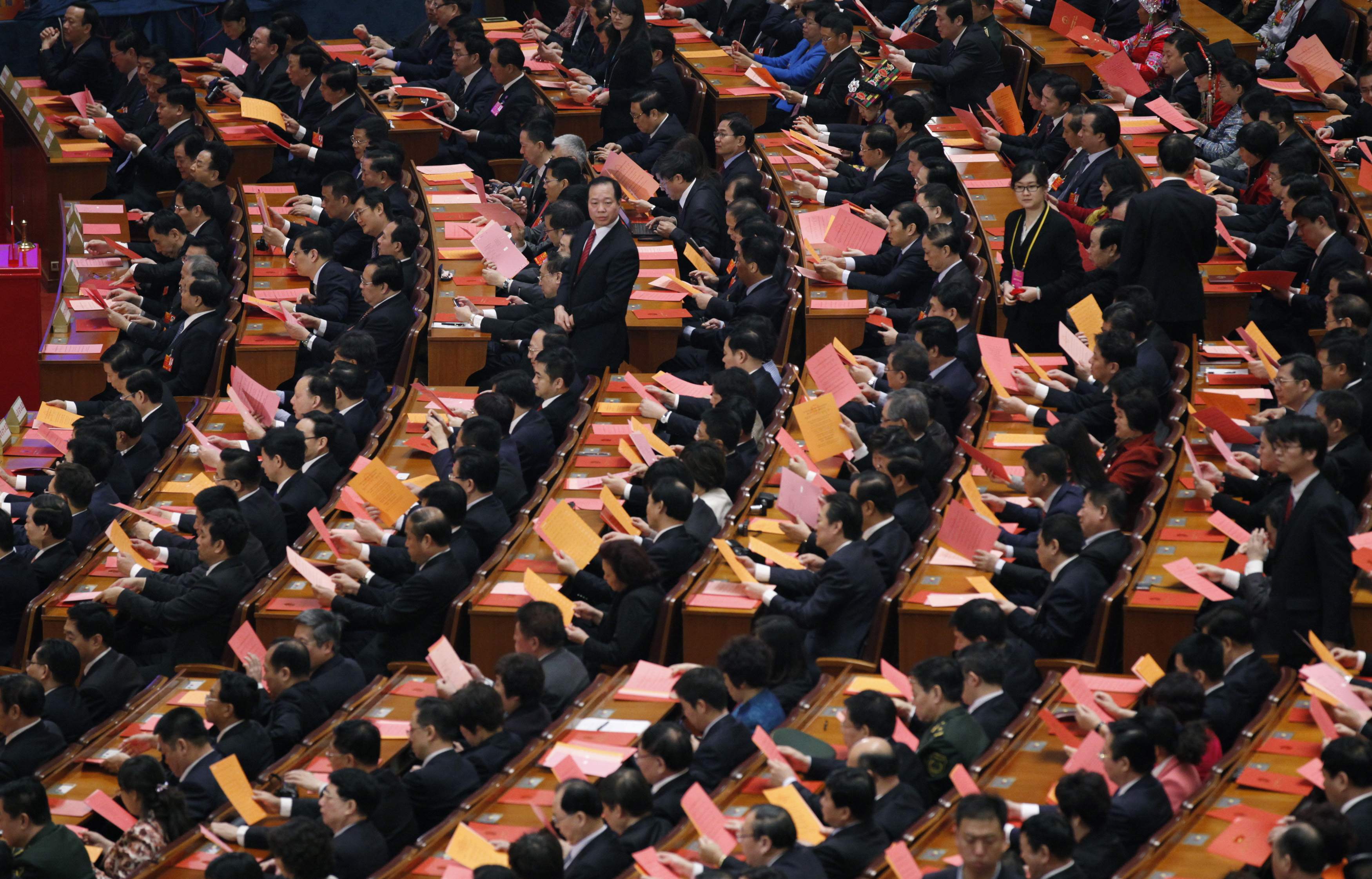 Delegates look at voting papers during the fifth plenary meeting of the National People's Congress at the Great Hall of the People in Beijing, March 15, 2013. Photo: Reuters