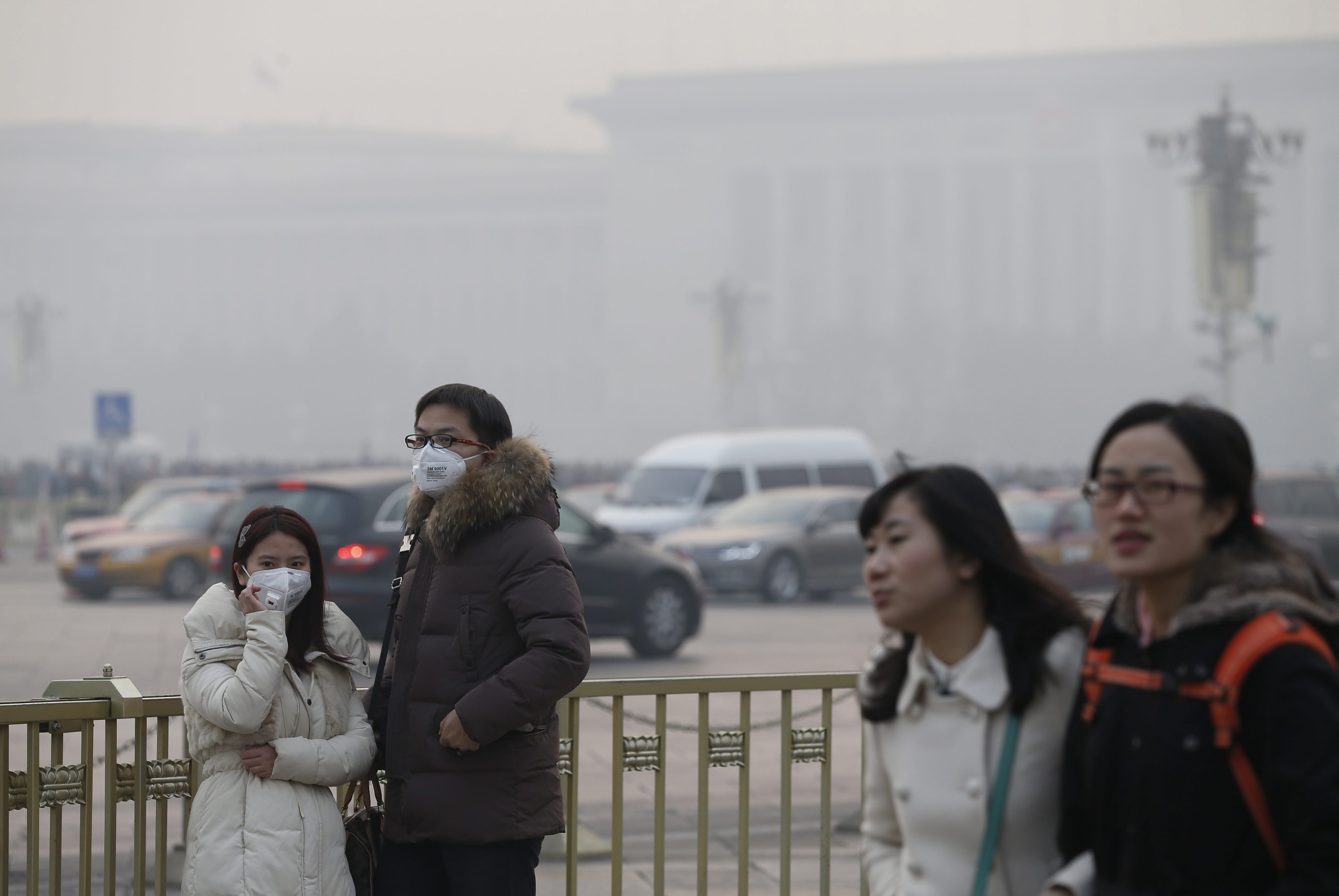 A Chinese couple wears protective masks while going around the Tiananmen Square on December 7, 2013. Photo: EPA