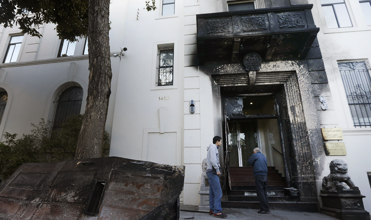 Two men look at the damage to the entrance of the Chinese Consulate in San Francisco on Thursday, Jan. 2, 2014. Photo: AP