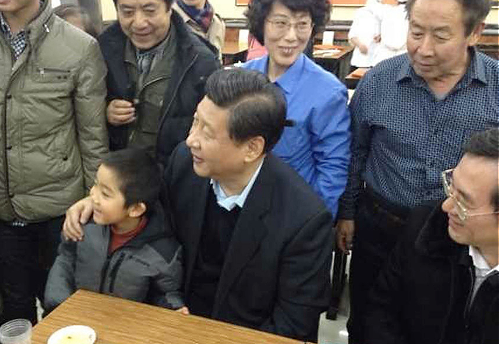 Chinese president Xi Jinping seen in a Beijing steamed bun restaurant taking a picture with a young boy on December 28, 2013. Photo: SCMP Pictures