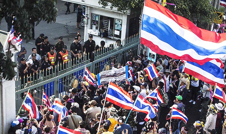 Protesters stand at the gate of the Custom Department office in Bangkok on Tuesday. Photo: Reuters