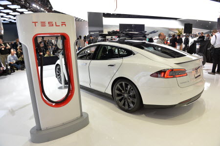 A Tesla electric car and a charging station, displayed at an American automotive show. Photo: AFP