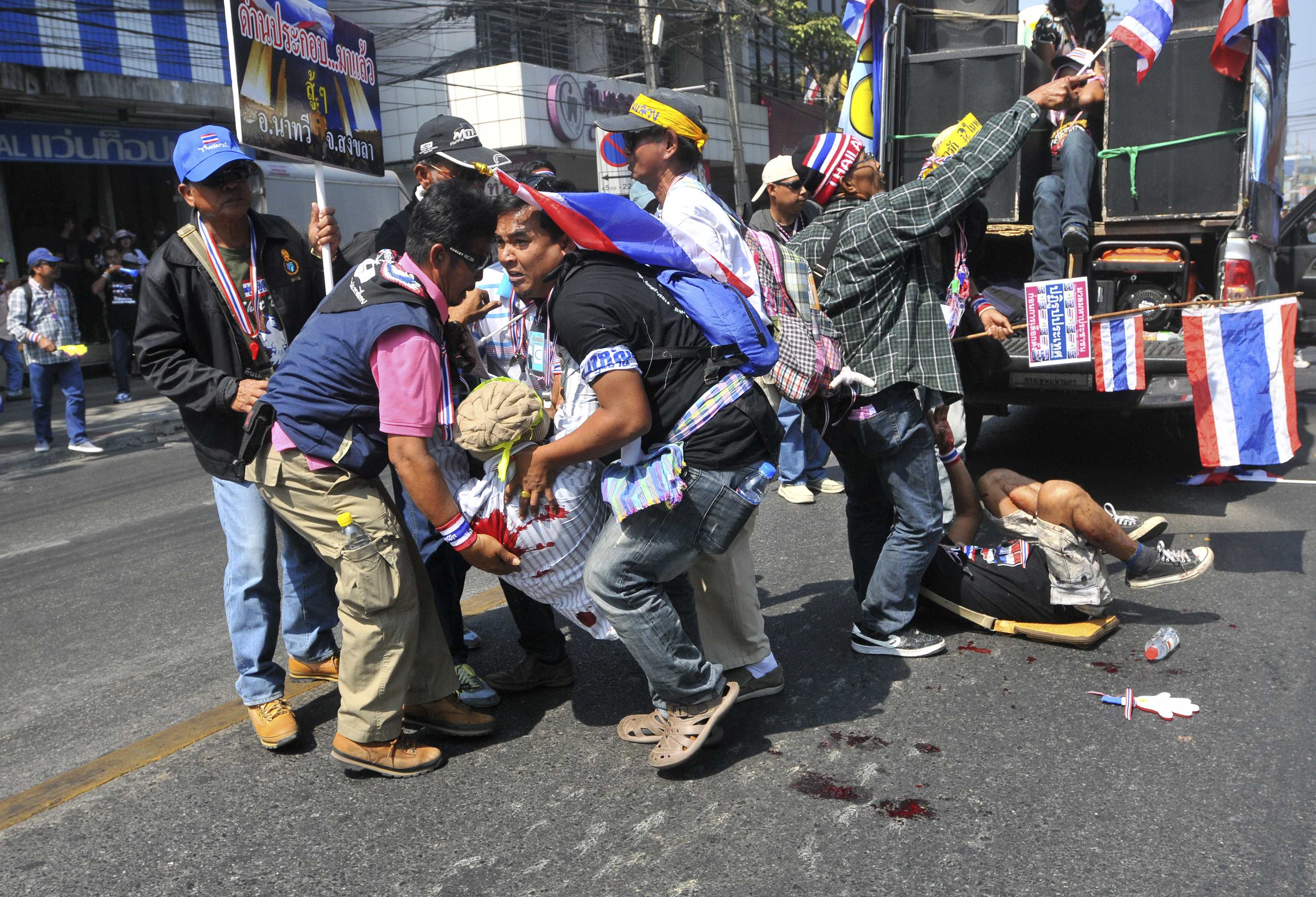 Thai protesters help the injured after an explosion during a rally in Bangkok on Friday. Photo: Reuters