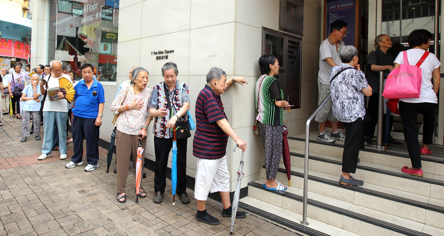 Citizens wait outside a bank for the subscription of the third issue of iBonds - which are issued by the government. The government could issue its first Islamic bond later this year. Photo: Dickson Lee

