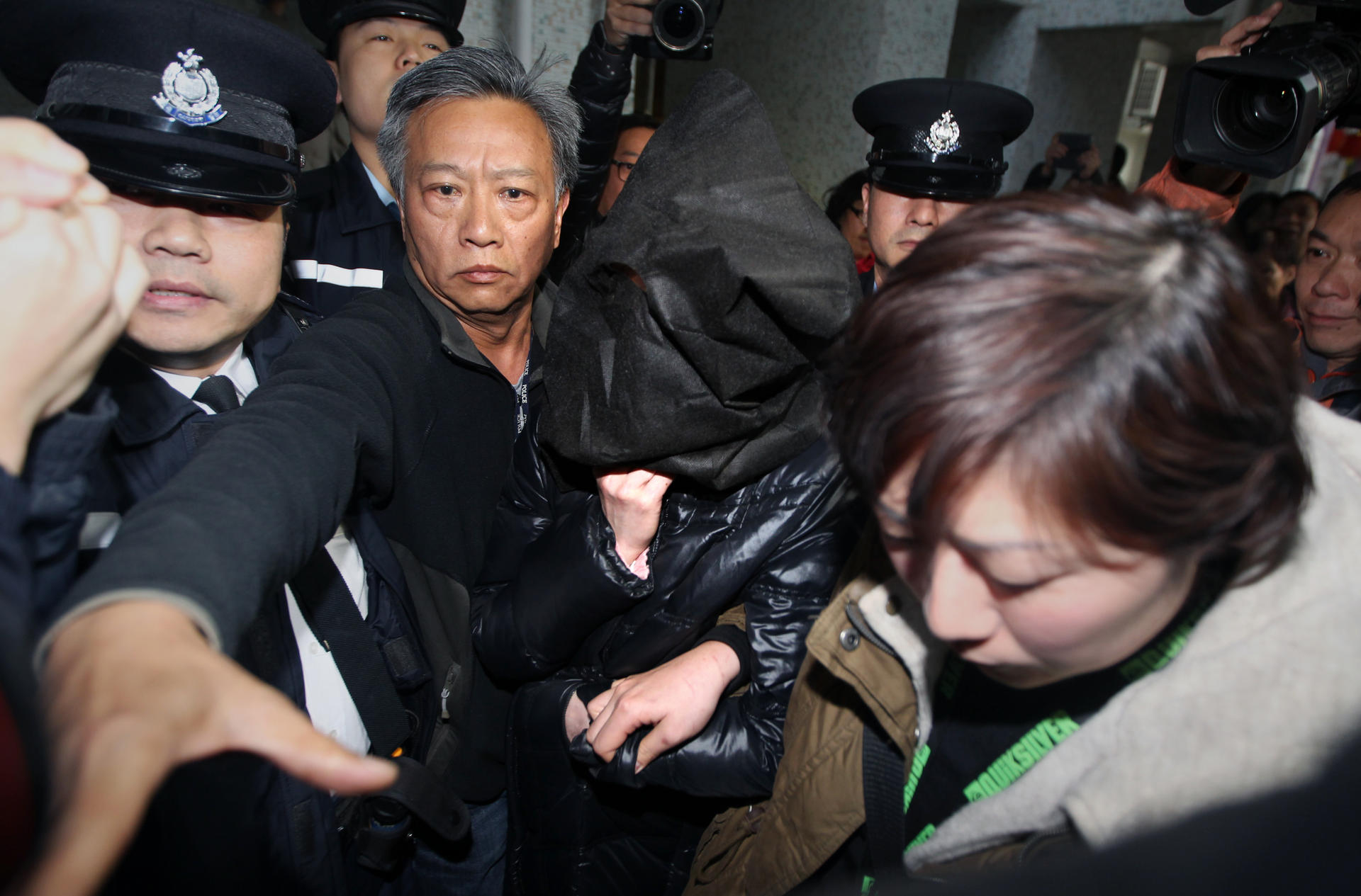 Suspect Lo Wan-tun is taken back to her Tseung Kwan O flat in a mask yesterday. Photo: Felix Wong