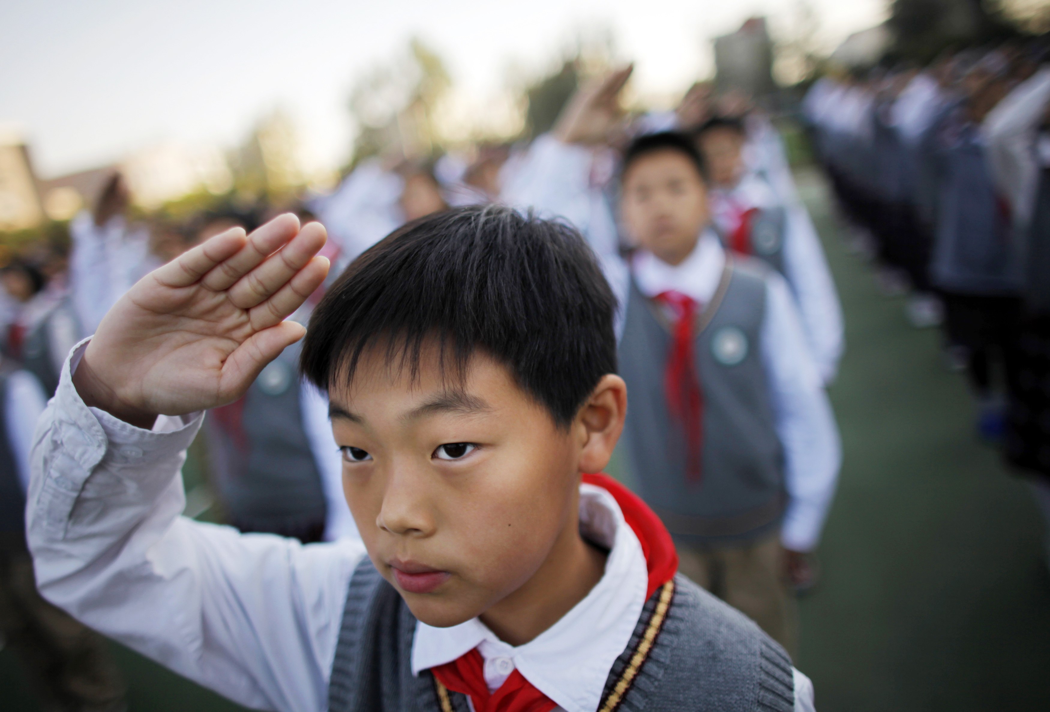 A student salutes during the weekly flag-raising ceremony at the East Experimental School in Shanghai. Kindergarten children will be encouraged to speak Shanghainese instead of Putonghua between classes. Photo: Reuters 