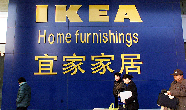 A customer carries her purchases as she leaves IKEA's new Beijing