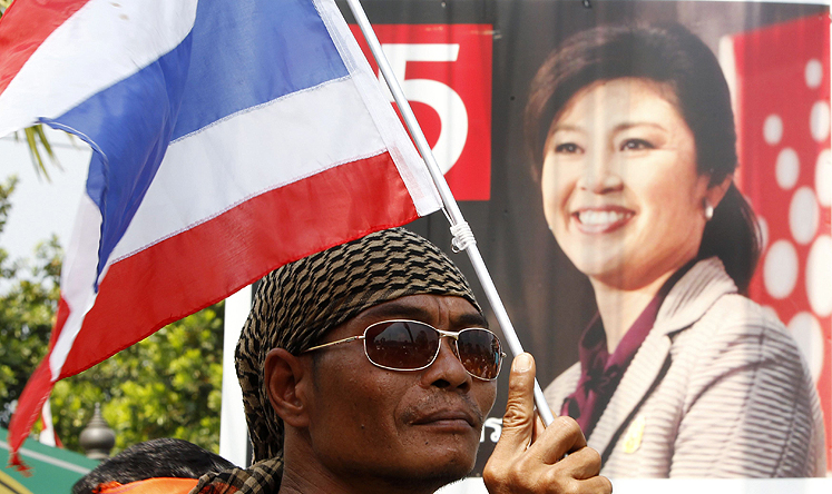 An anti-government protester holds a national flag during a rally on the outskirts of Bangkok. Photo: Reuters
