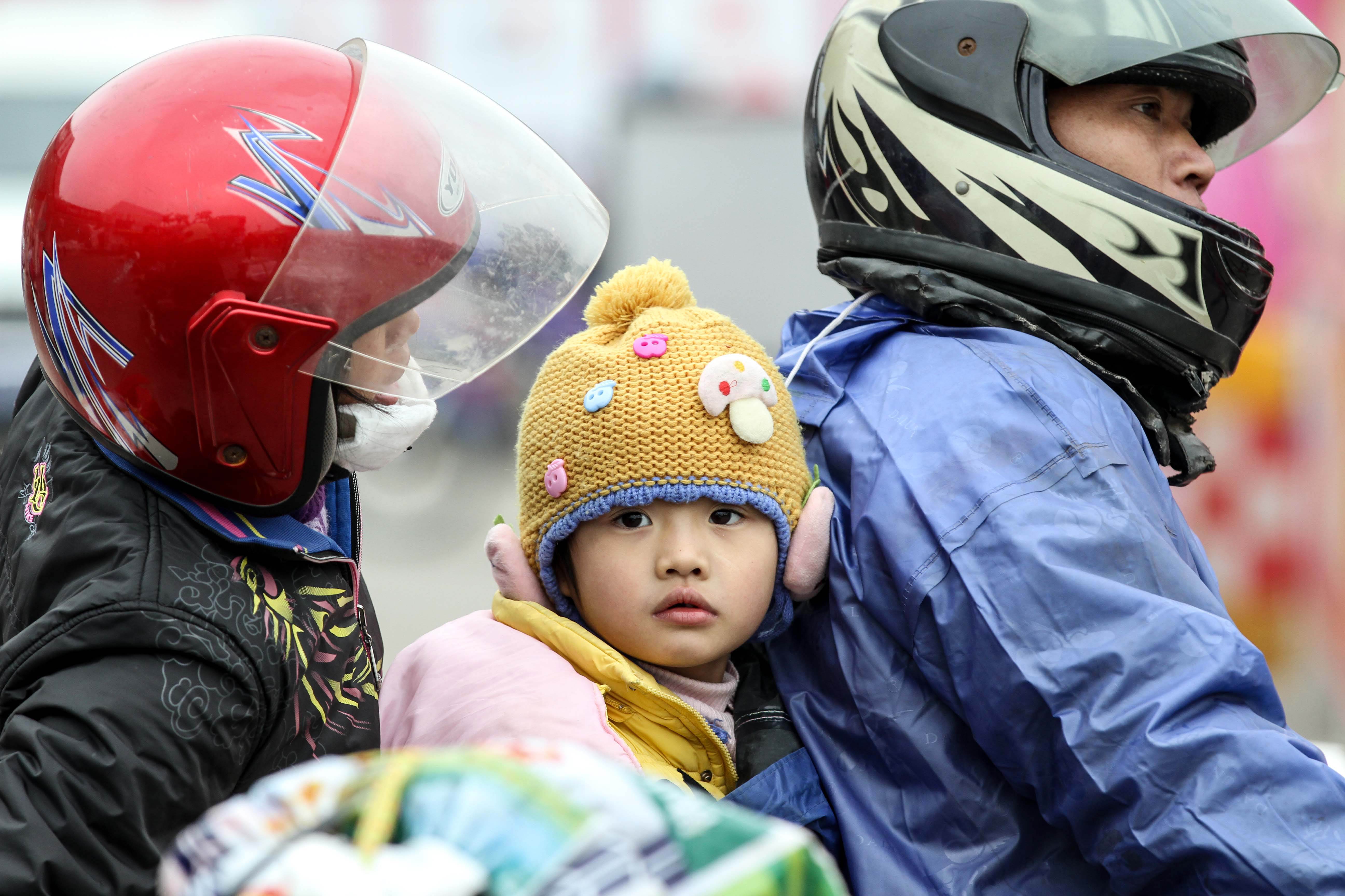 A Chinese family arrive on a motorcycle at a pit stop in Wuzhou, Guangxi province. Photo: AFP