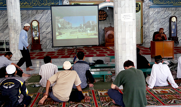 Muslim men watch a slideshow from Syria during a prayer calling for jihad at a mosque in Jakarta. Photo: AP