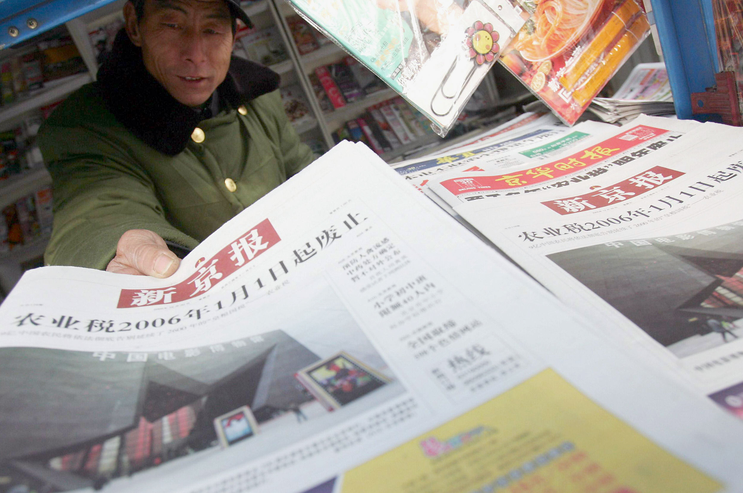 A vendor offering a copy of The Beijing News at a newsstand in the capital. Photo: AFP