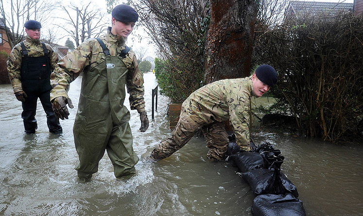 Soldiers attempt to protect a flood-affected property with sandbags in Wraysbury. Photo: AFP