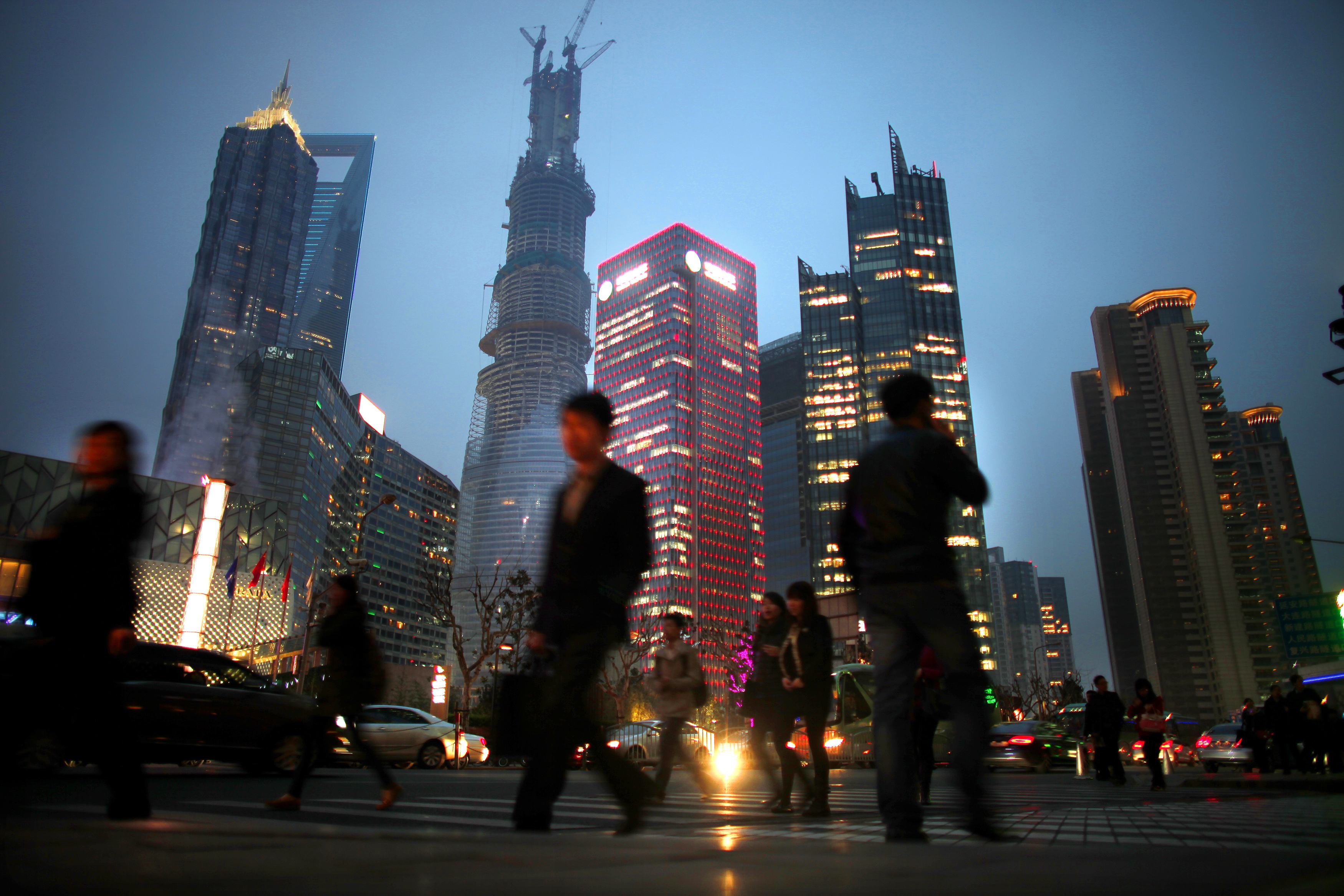 People walk along a busy street at Pudong financial district in Shanghai, in this March 27, 2013 file photo. Photo: Reuters