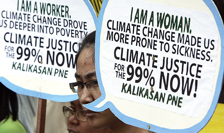 Protesters display placards at a rally in Manila to mark World Climate Day. Photo: AP