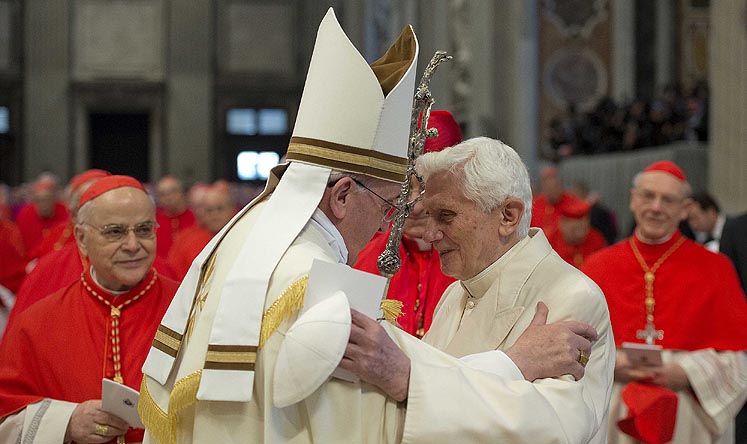 Pope Francis greets Pope Emeritus Benedict XVI in Saint Peter's Basilica at the Vatican in Rome