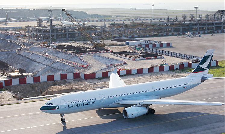 A Cathay Pacific aircraft on the runway adjacent to the construction site of the mid-field development at Hong Kong International Airport. Photo: Nora Tam