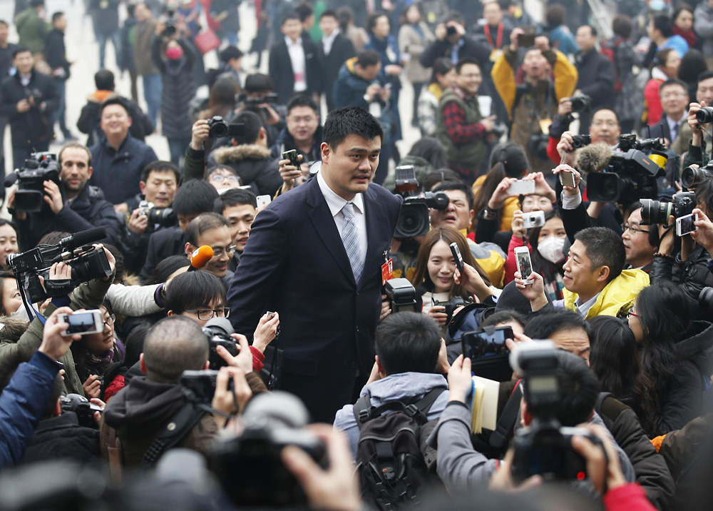 Yao Ming (centre) towers over reporters as he heads to the CPPCC meetings in Beijing. Photo: Reuters
