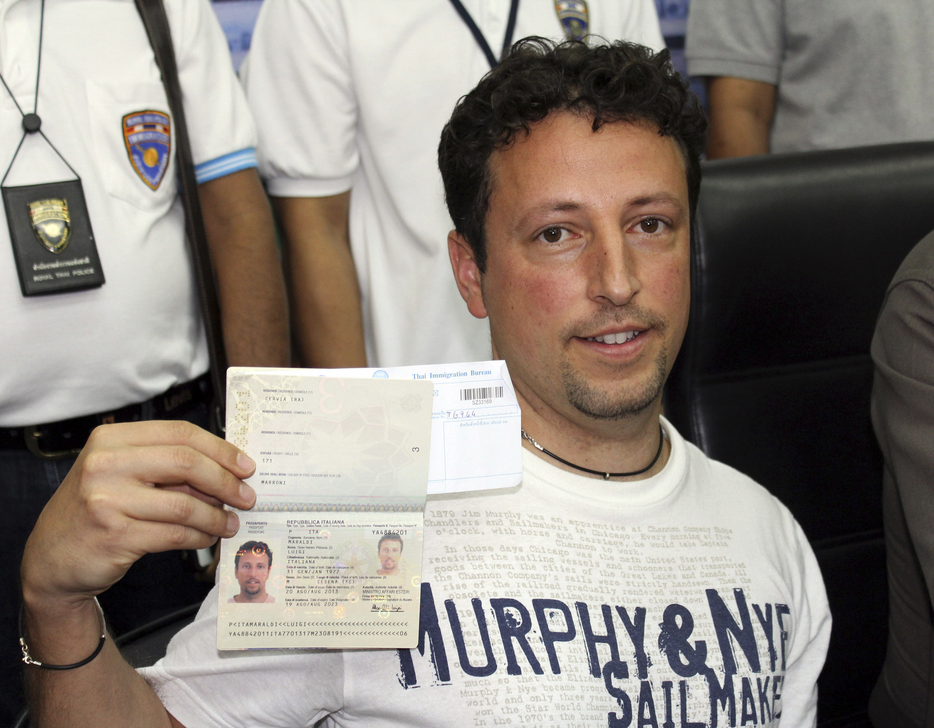 Italian Luigi Maraldi, whose stolen passport was used by a passenger boarding the missing Malaysia airlines flight 370, shows his passport as he reports himself to Thai police at Phuket police station in Thailand. Photo: AP