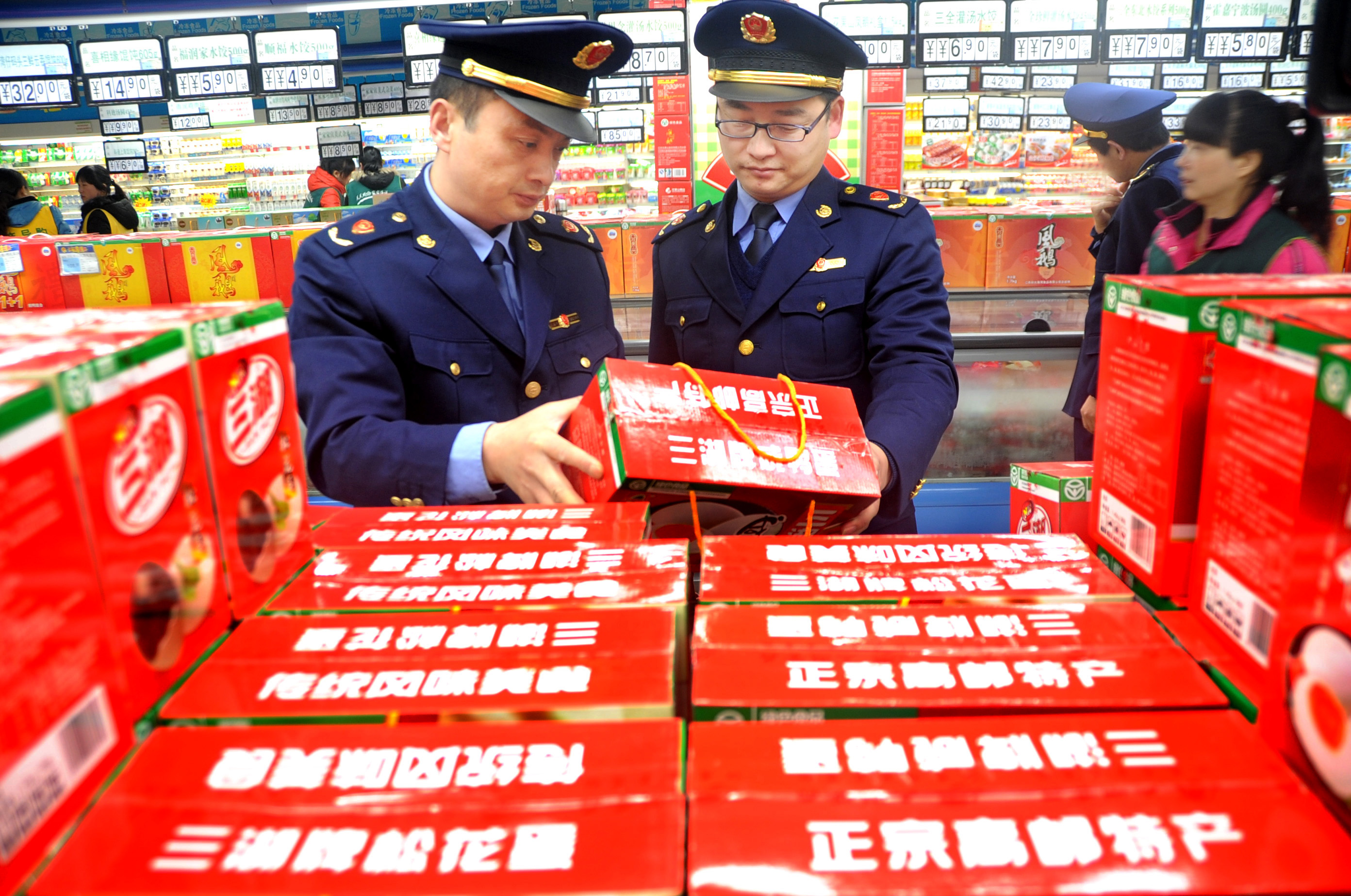 Staff members of the commerce and industry bureau check the quality information of food in a supermarket ahead of the World Consumer Rights Day in Lianyungang, east China's Jiangsu Province. Photo: Xinhua
