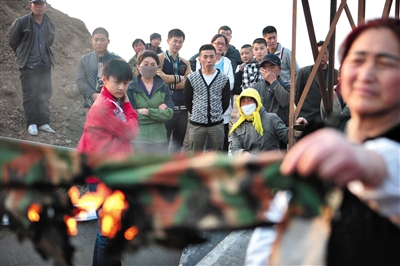 Villagers gather around the debris of the tent that was set on fire on March 21. Photo: Weibo 