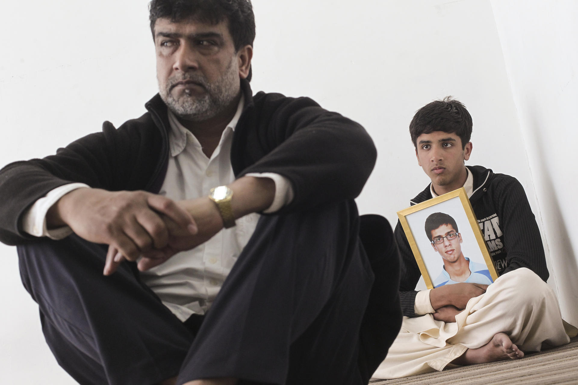 Muhammad Akthar with his son, Sharaz, who is holding a picture of his late brother, Shazad Rangzeb. Photos: May Tse; Anna Healy Fenton; Apple Daily
