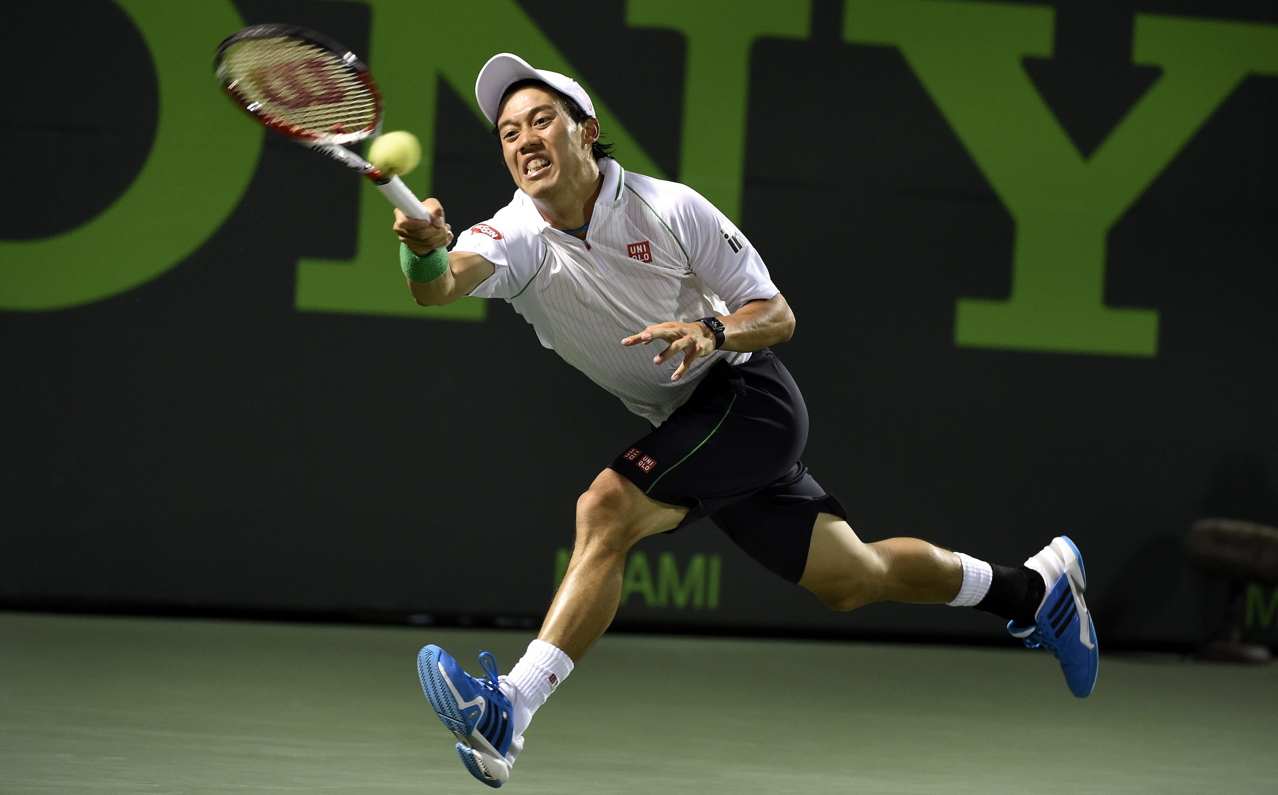 Kei Nishikori returns the ball to Roger Federer in their quarter-final on Key Biscayne in Miami, Florida. Photo: EPA