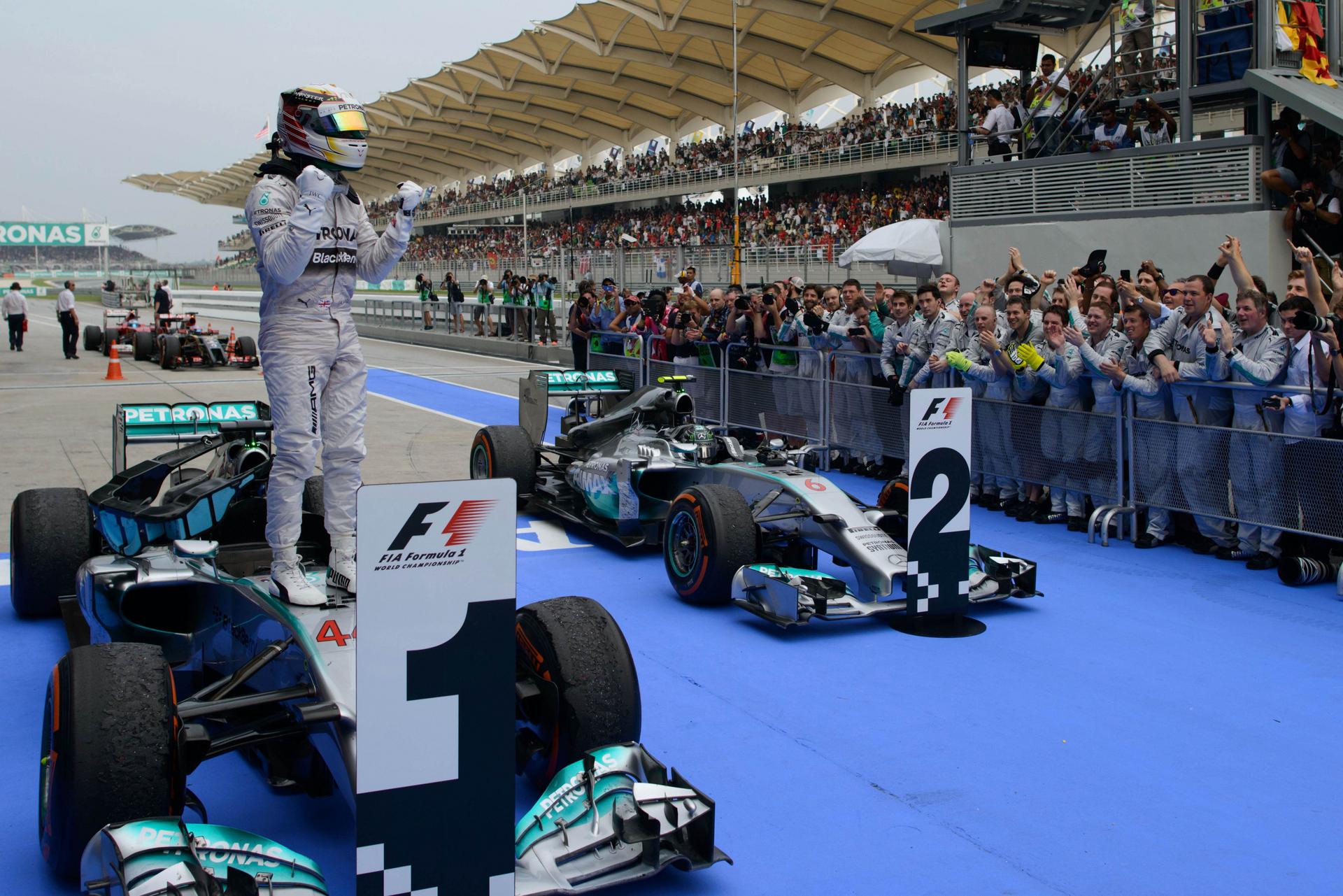 Mercedes' Lewis Hamilton of Britain stands on his car after winning the Malaysian Grand Prix in a one-two finish for his team. Photo: AFP