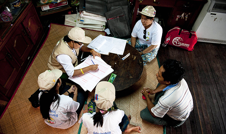 Workers collect census data from a family in Yangon on Sunday. Photo: AP