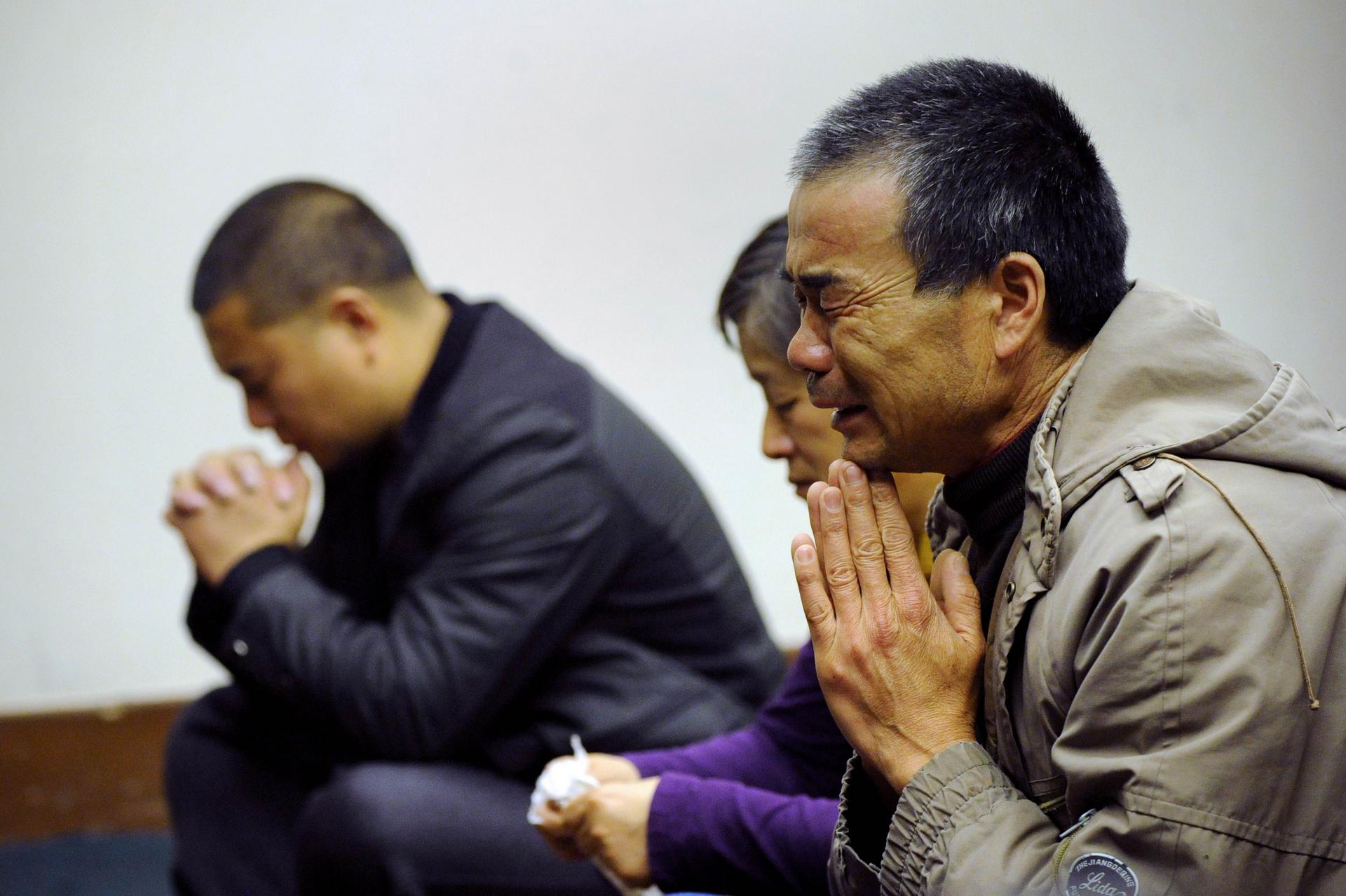 Chinese relatives pray at the Lido Hotel in Beijing. Photo: Reuters