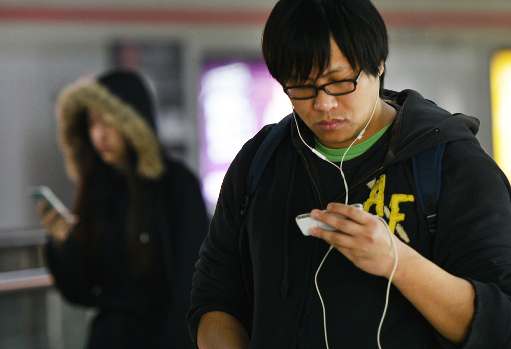 People use their mobile devices in a metro station in Shanghai on March 12, 2014. Photo: AFP