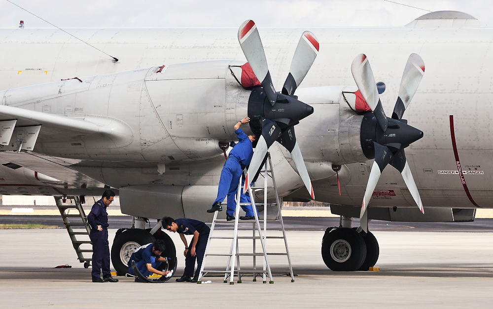 Japanese ground crew prepare a Japanese Air Force Orion plane for takes off from Pearce Airbase near Perth to join the hunt for the missing MH370 plane in the Indian Ocean on April 6, 2014. Photo: AFP