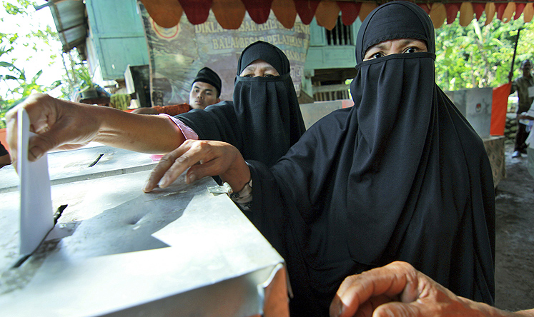 Members of An-Nadzir Muslim sect cast their ballots at a polling station in South Sulawesi, Indonesia on Wednesday. Photo: AP