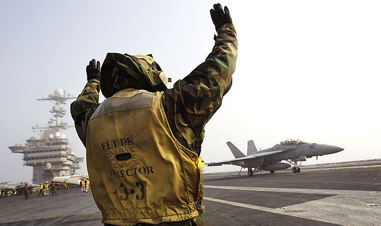 Flight deck crew signal a US Navy F-18 jet fighter on the deck of the USS George Washington aircraft carrier during a joint military exercise with South Korea. Photo: AP