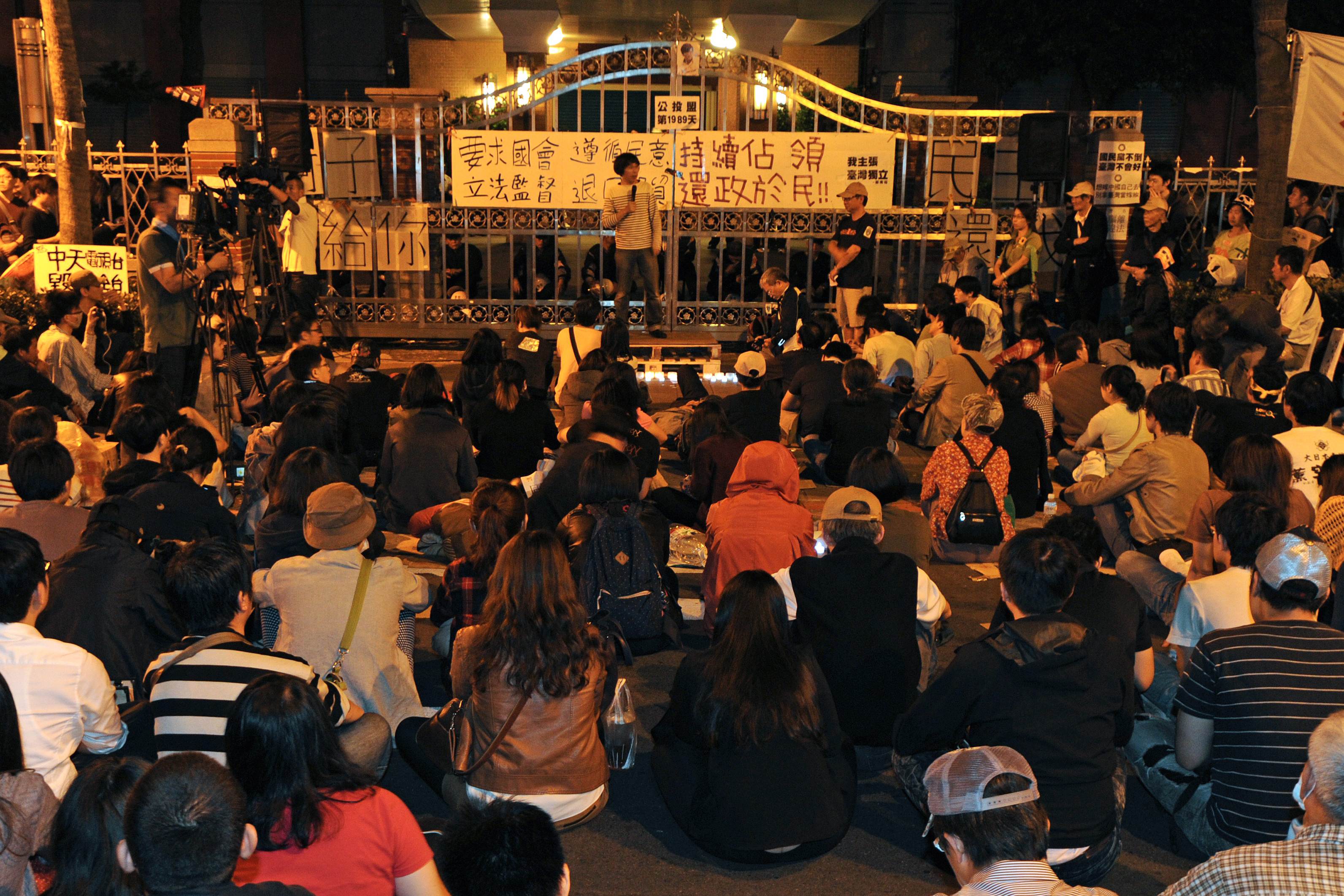 Students protesters sit on the ground in front of the Parliament in Taipei, late in the evening of April 11, 2014.