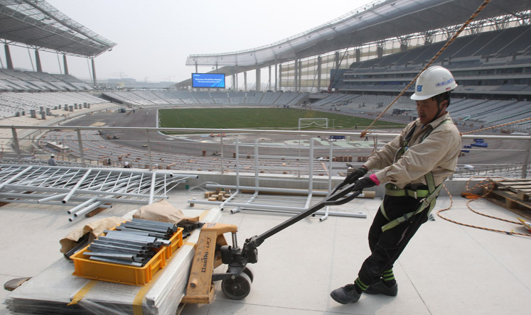 A labourer works at the main stadium for the 2014 Asian Games in South Korea. Vietnam says high costs are one reason it has withdrawn as host for the 2019 Games. Photo: AP