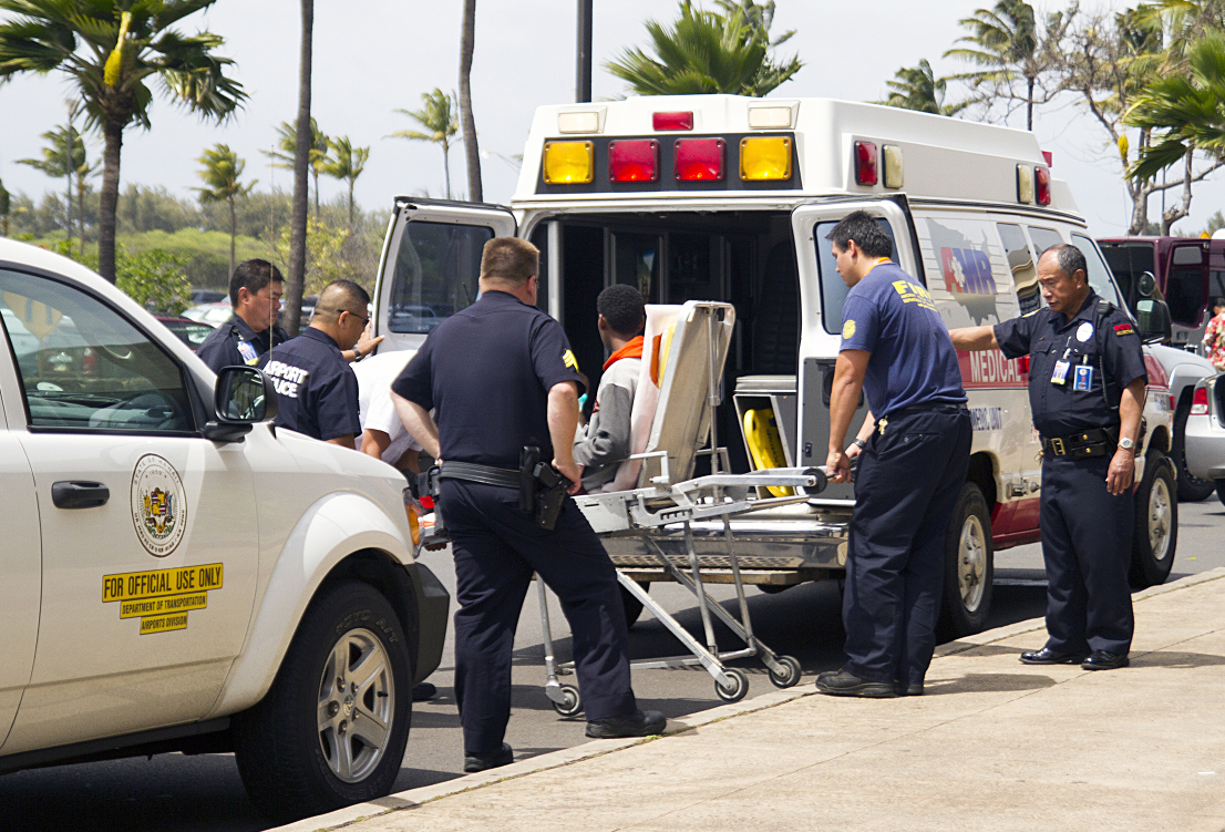 The teenage stowaway sits on a stretcher as he is carried to an ambulance in Kahului Airport, in Maui, Hawaii, on Sunday afternoon. Photo: AP
