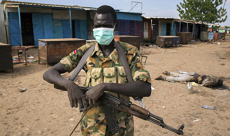 A rebel fighter wears a mask near a body in front of a mosque where people were massacred at in Bentiu, South Sudan. Photo: Reuters