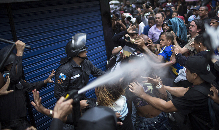 A woman is pepper sprayed as residents of the Pavao-Pavaozinho slum clash with riot police during a protest in Rio de Janeiro on Thursday. Photo: AP