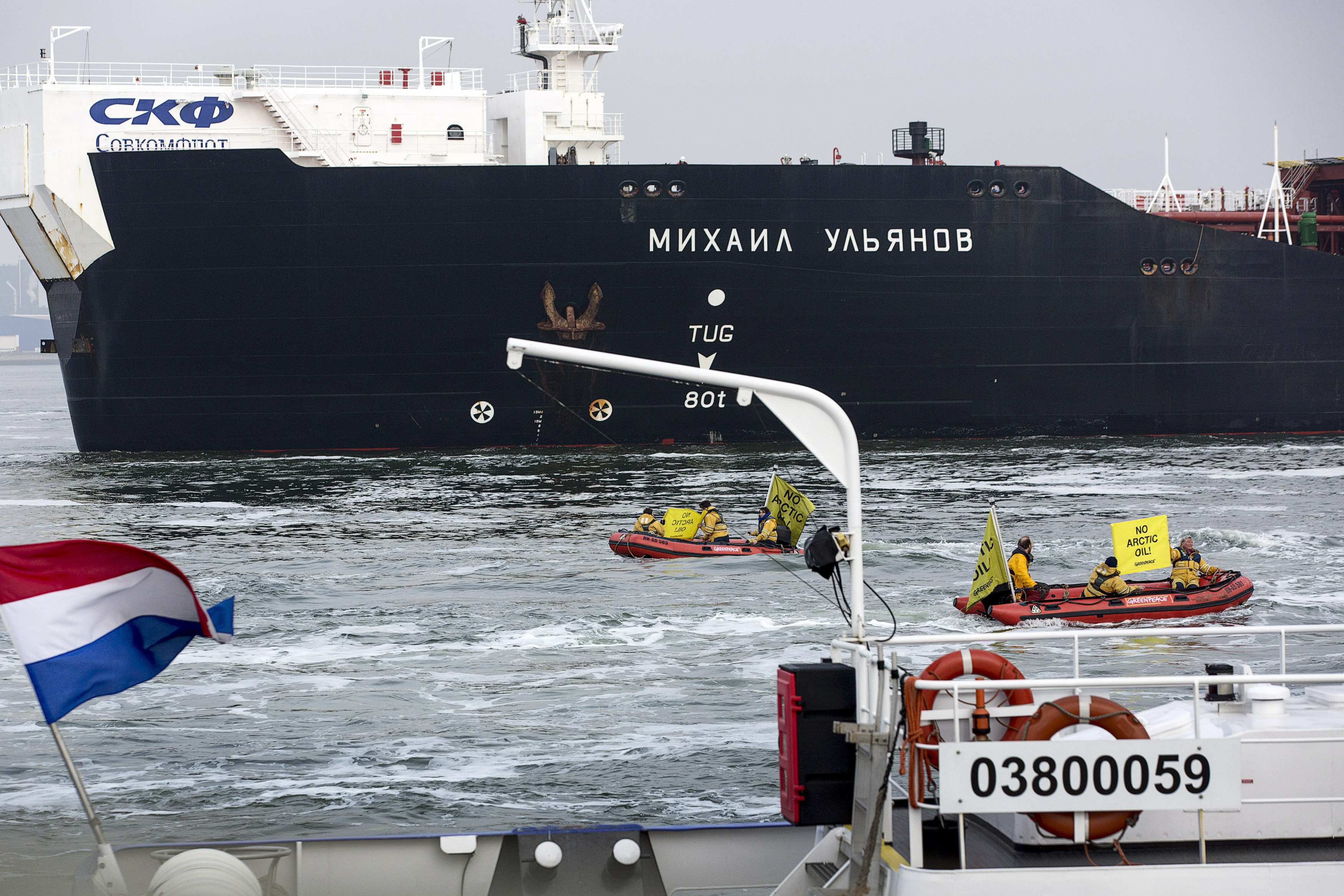 Members of Greenpeace sail past the Russian oil tanker Mikhail Ulyanov in the harbour of Rotterdam yesterday. Photo: Reuters