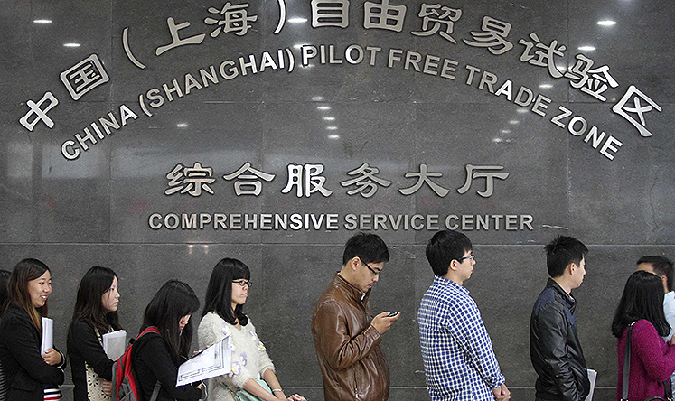 People queue up at an office of the service centre of China (Shanghai) Pilot Free Trade Zone, in Shanghai. Photo: Reuters