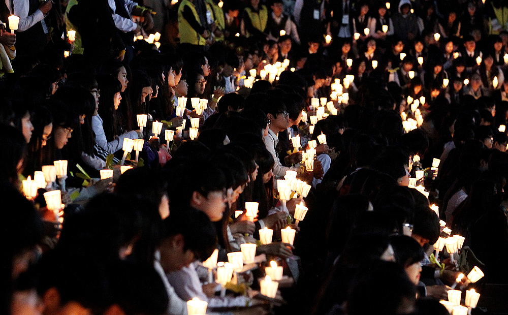High school students hold candles during a rally to pay tribute to the victims and missing passengers of the sunken ferry Sewol in Ansan, South Korea on Friday. Photo: AP