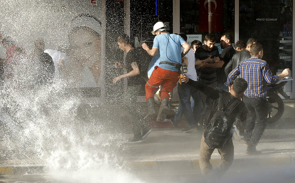 Protesters try to escape the jet of an advancing police water cannon during a protest on Friday against the government after the mine explosion in Soma. Photo: EPA