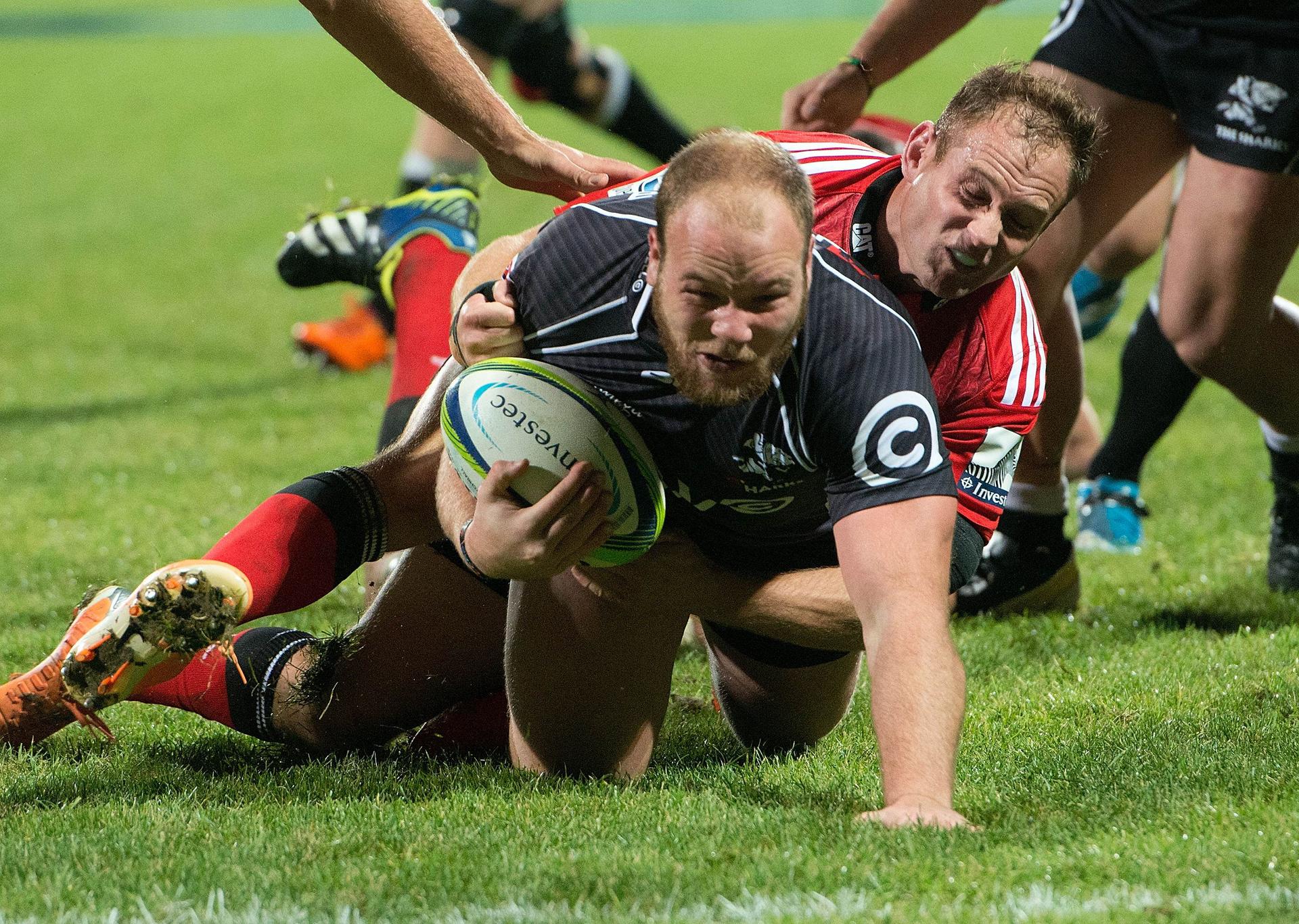 Kyle Cooper of the Coastal Sharks scores a try as he is tackled by Andy Elis of the Crusaders on Saturday at AMI Stadium in Christchurch. Photo: AFP