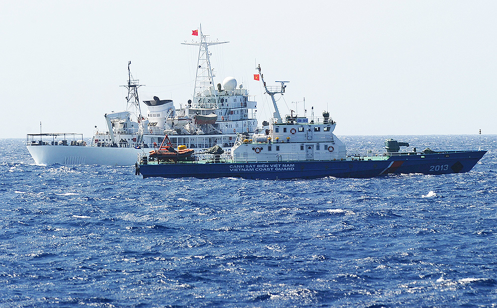 Chinese coastguard ship sails close to a Vietnamese coastguard vessel (front) near China's oil drilling rig in disputed waters in the South China Sea. Photo: AFP