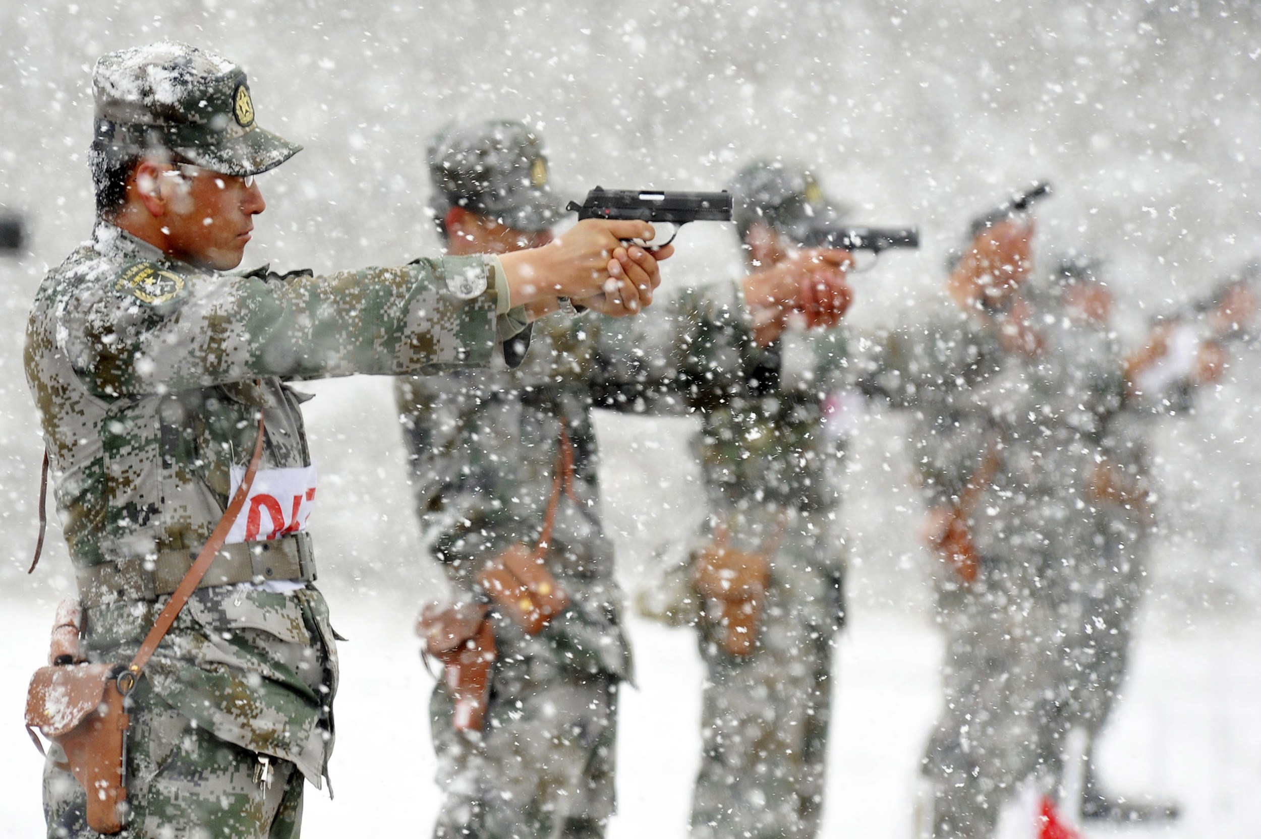 People's Liberation Army (PLA) soldiers practice shooting with pistols at a military base amid heavy snowfalls in Hami, Xinjiang. Photo: Reuters