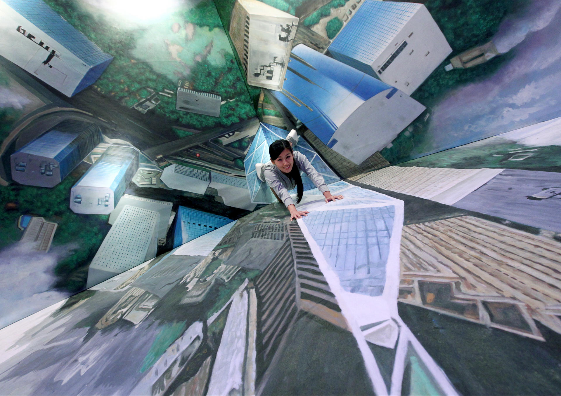 Model Liz Li poses against a 3-D painting of the Bank of China building at the museum. Photo: May Tse