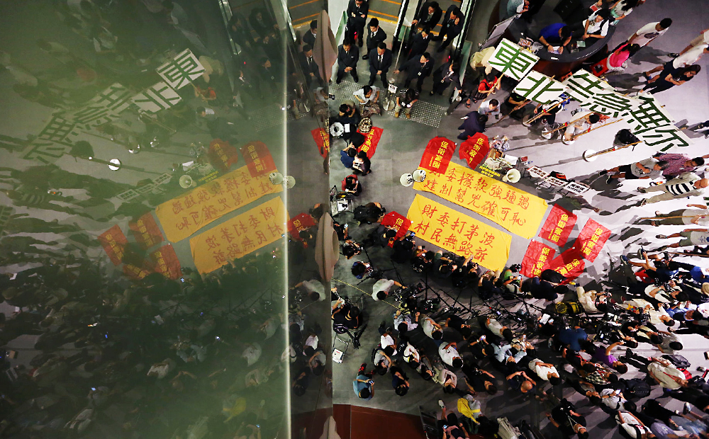 Opponents of the northeastern New Territories development plan protest on the ground floor of the Legco complex. Photo: Felix Wong