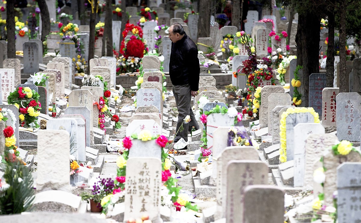 A man looks for his family grave at the Babaoshan cemetery during the Qingming Festival in Beijing. Photo: AP