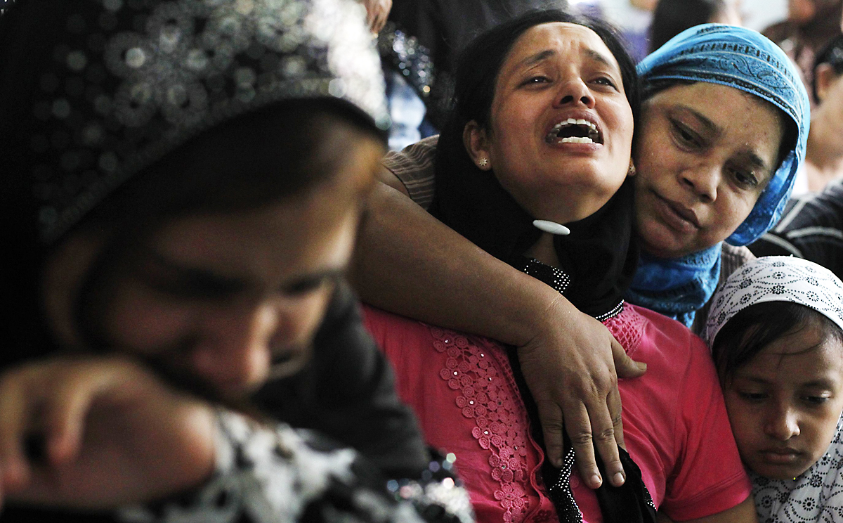 Tin Tin Kyaw (centre) cries near the body of her husband Soe Min, a 51-year-old man who was killed in the riot, at a mosque in Mandalay. Photo: Reuters